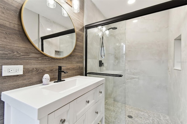 full bath with a shower stall, tile walls, and vanity