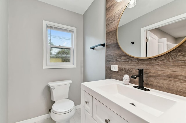 half bath with toilet, tasteful backsplash, vanity, and baseboards