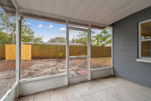 unfurnished sunroom with vaulted ceiling, wood ceiling, and a healthy amount of sunlight