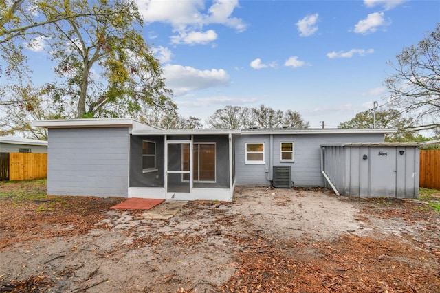 back of house featuring a storage shed, central AC, fence, and a sunroom