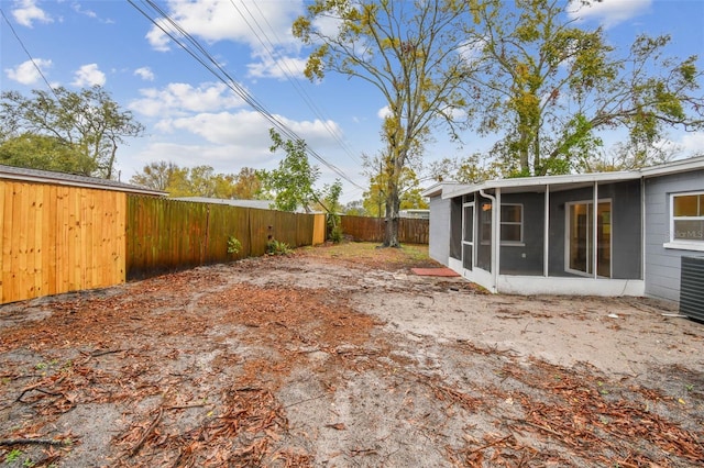 view of yard featuring a fenced backyard and a sunroom