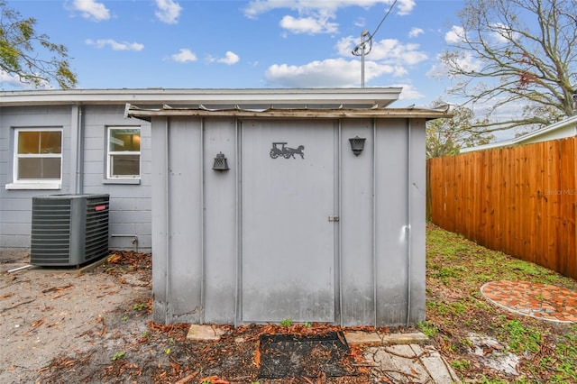 view of shed featuring fence and central AC unit