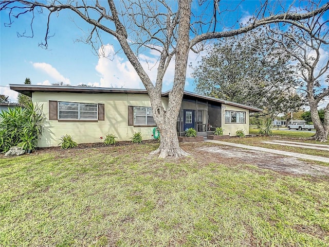 ranch-style house with a sunroom and a front lawn