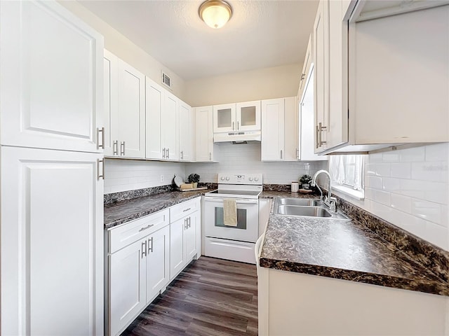 kitchen featuring dark countertops, white electric range, under cabinet range hood, white cabinetry, and a sink