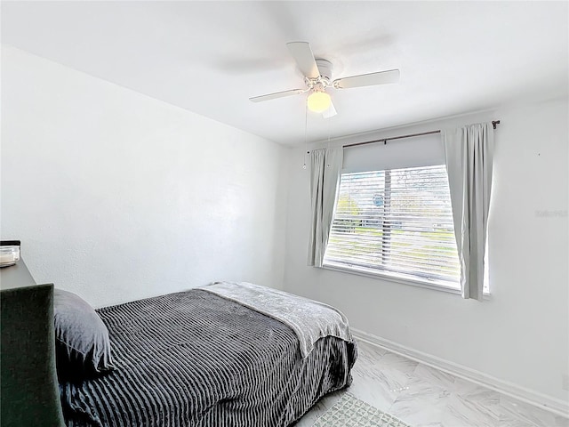 bedroom with a ceiling fan and baseboards