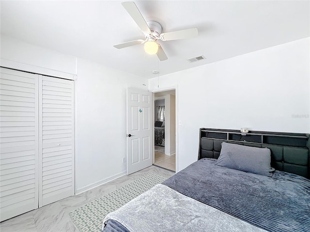 bedroom with baseboards, visible vents, a ceiling fan, marble finish floor, and a closet