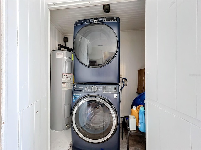 clothes washing area featuring stacked washer / dryer, laundry area, and water heater