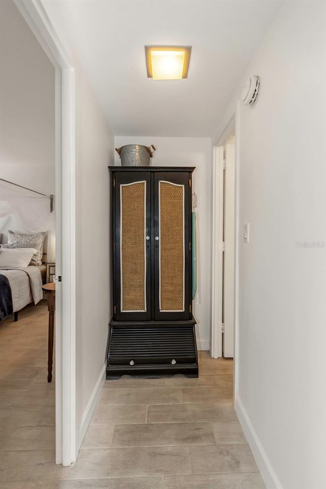 corridor with baseboards and light wood-style floors