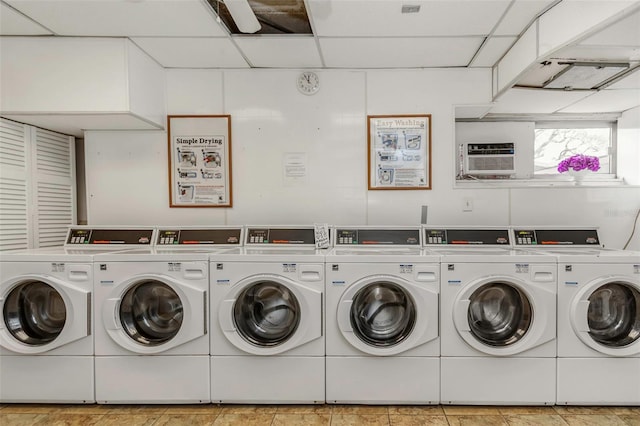 shared laundry area with an AC wall unit and washing machine and dryer