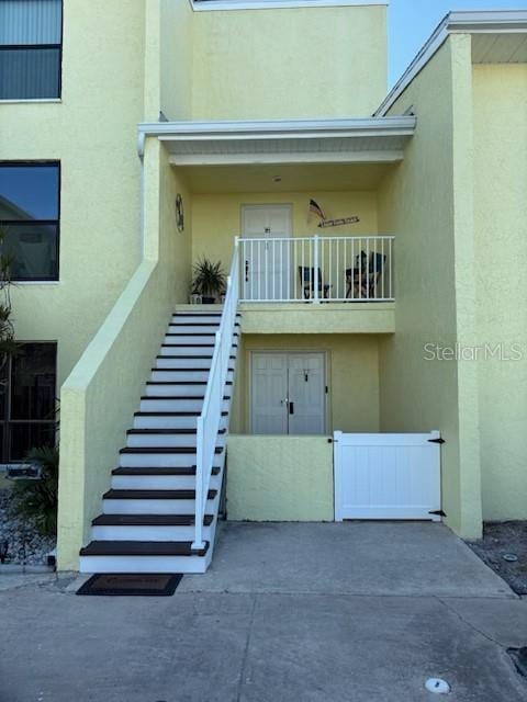 doorway to property featuring a balcony and stucco siding