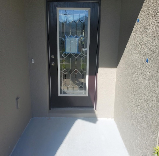 property entrance with stucco siding