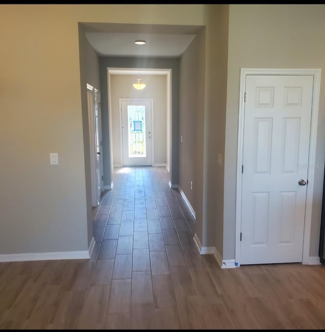 hallway featuring baseboards and wood finished floors