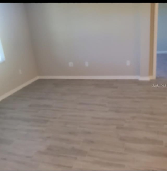 empty room with light wood-type flooring and baseboards