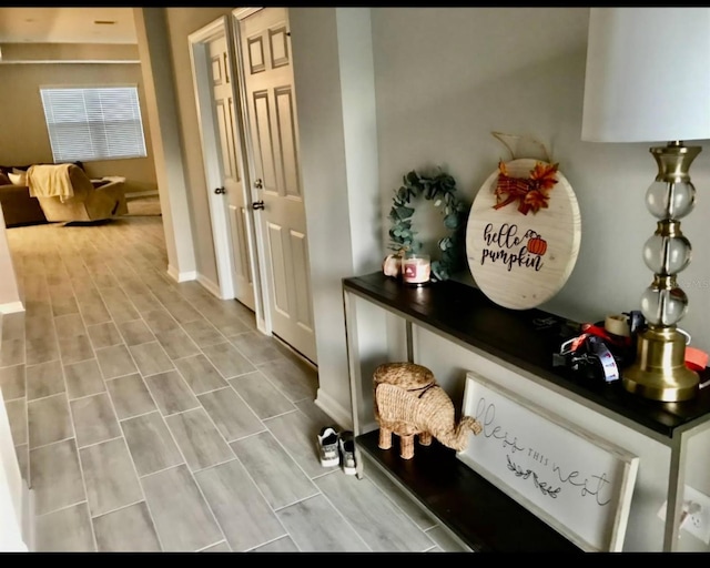 hallway featuring wood finish floors and baseboards