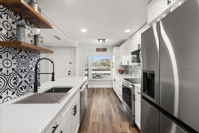 kitchen with light countertops, appliances with stainless steel finishes, open shelves, and white cabinets