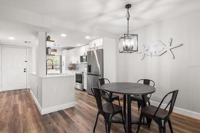 dining area featuring dark wood-type flooring and baseboards