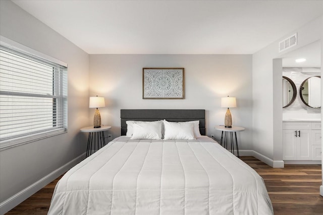 bedroom with baseboards, visible vents, and dark wood finished floors