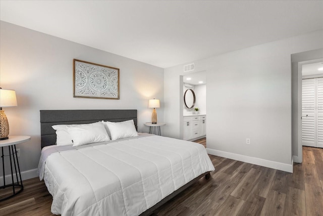 bedroom featuring baseboards, visible vents, dark wood finished floors, and connected bathroom