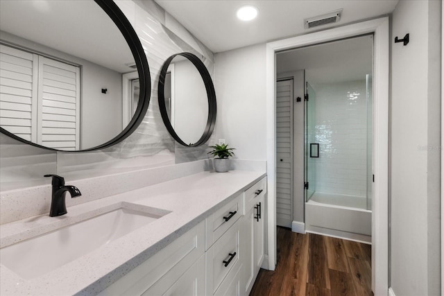 bathroom with  shower combination, visible vents, wood finished floors, and vanity