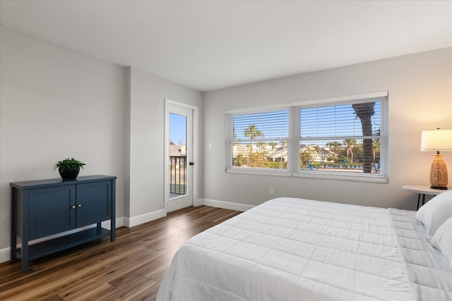 bedroom with access to exterior, baseboards, and dark wood-type flooring