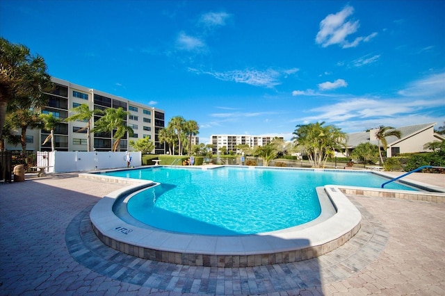 community pool featuring fence and a patio