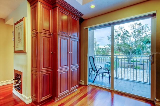 doorway with light wood-style flooring and baseboards