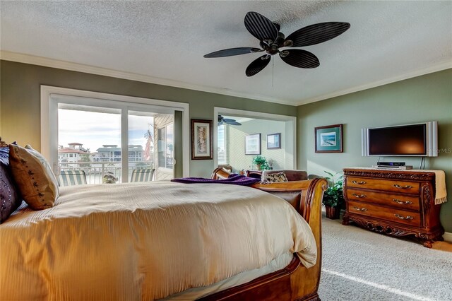 bedroom featuring a textured ceiling, ornamental molding, carpet, and access to exterior