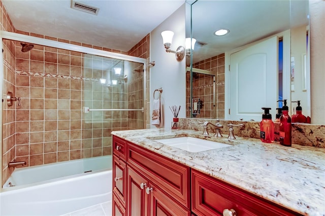 full bath featuring shower / bath combination with glass door, vanity, and visible vents