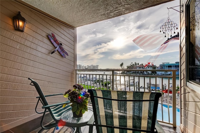 balcony with a water view and a view of city