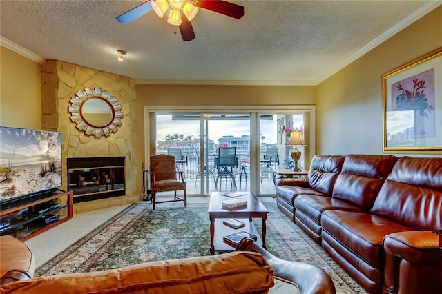 carpeted living room featuring a ceiling fan, a fireplace, ornamental molding, and a textured ceiling