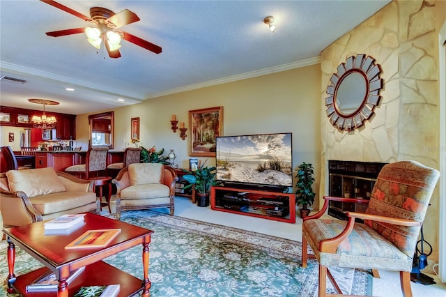 living room featuring visible vents, a textured ceiling, crown molding, a fireplace, and ceiling fan with notable chandelier