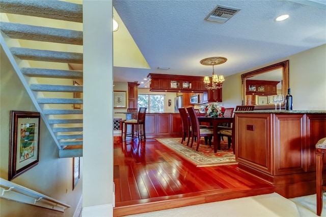 dining room featuring a notable chandelier, recessed lighting, wood-type flooring, visible vents, and a textured ceiling