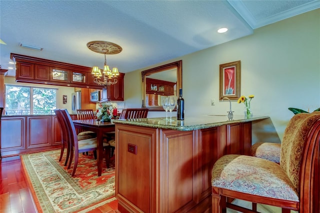 kitchen with a peninsula, light wood finished floors, visible vents, and stainless steel appliances