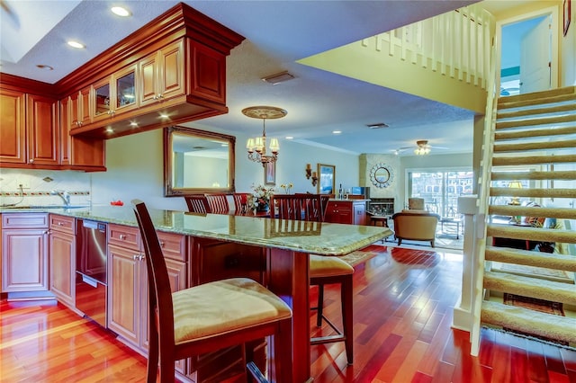 kitchen with light wood-type flooring, visible vents, decorative backsplash, and light stone counters