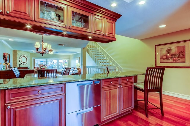 kitchen featuring dark wood finished floors, an inviting chandelier, stone countertops, glass insert cabinets, and dishwasher