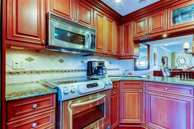 kitchen featuring tasteful backsplash, appliances with stainless steel finishes, a sink, and light stone countertops