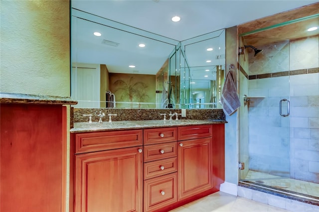 full bath with double vanity, a stall shower, visible vents, and a sink