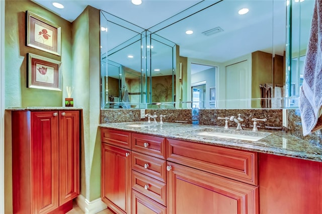 bathroom featuring recessed lighting, visible vents, a sink, and double vanity