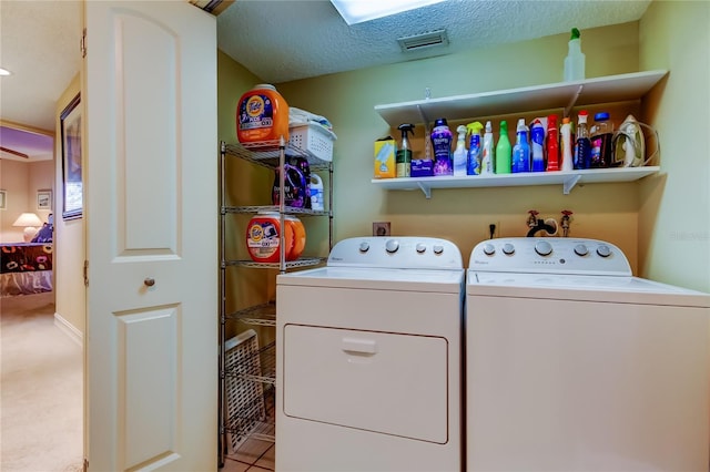 washroom with laundry area, washing machine and dryer, visible vents, and a textured ceiling