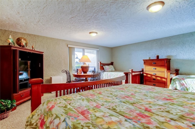 bedroom with carpet floors, a textured ceiling, and a textured wall