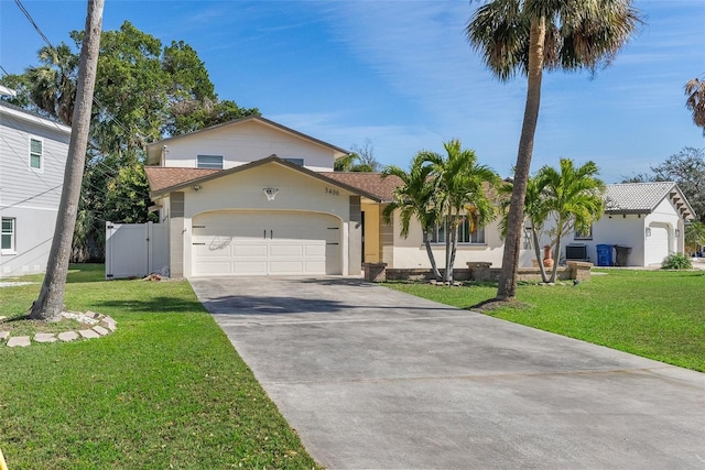 view of front of property featuring a garage, concrete driveway, a front lawn, and stucco siding