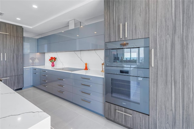 kitchen with light stone counters, light tile patterned floors, gray cabinetry, modern cabinets, and black electric cooktop