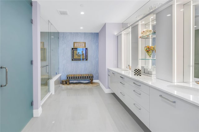 bathroom with an accent wall, a stall shower, and a sink