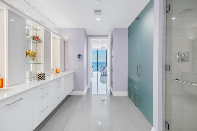 bathroom featuring double vanity, visible vents, a stall shower, a sink, and baseboards