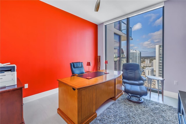 home office with a view of city, floor to ceiling windows, and baseboards