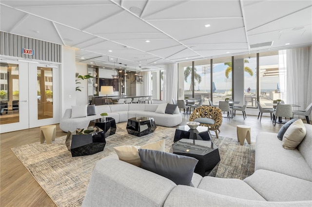 living area featuring french doors, recessed lighting, wood finished floors, and floor to ceiling windows