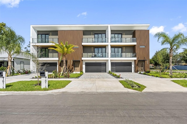 view of property featuring a garage and decorative driveway