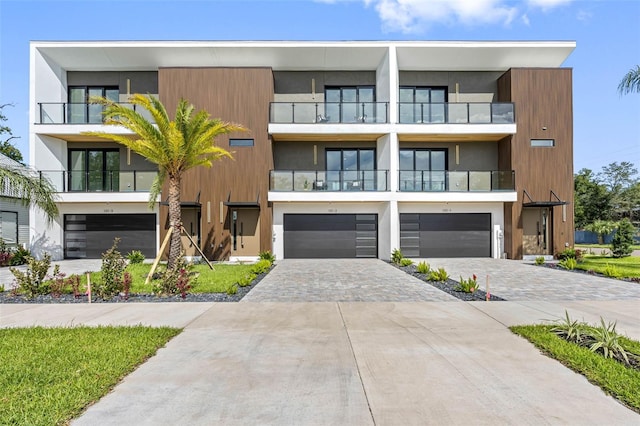 view of front of house with a garage, decorative driveway, and stucco siding