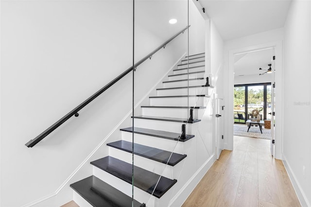 stairs with wood finished floors and baseboards