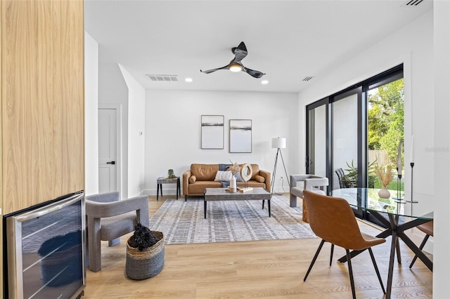 living area featuring recessed lighting, wood finished floors, a ceiling fan, baseboards, and visible vents